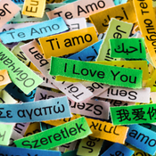 Layered and overlapping slips of paper in different languages that all mean "I love you".