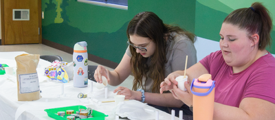 Two teens working on a craft.